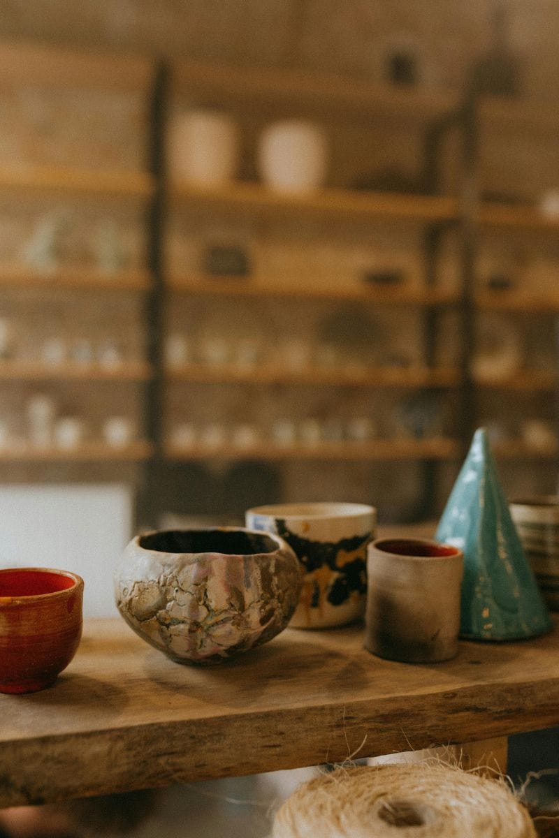 Ceramic bowls on a wooden table with shelves in the background