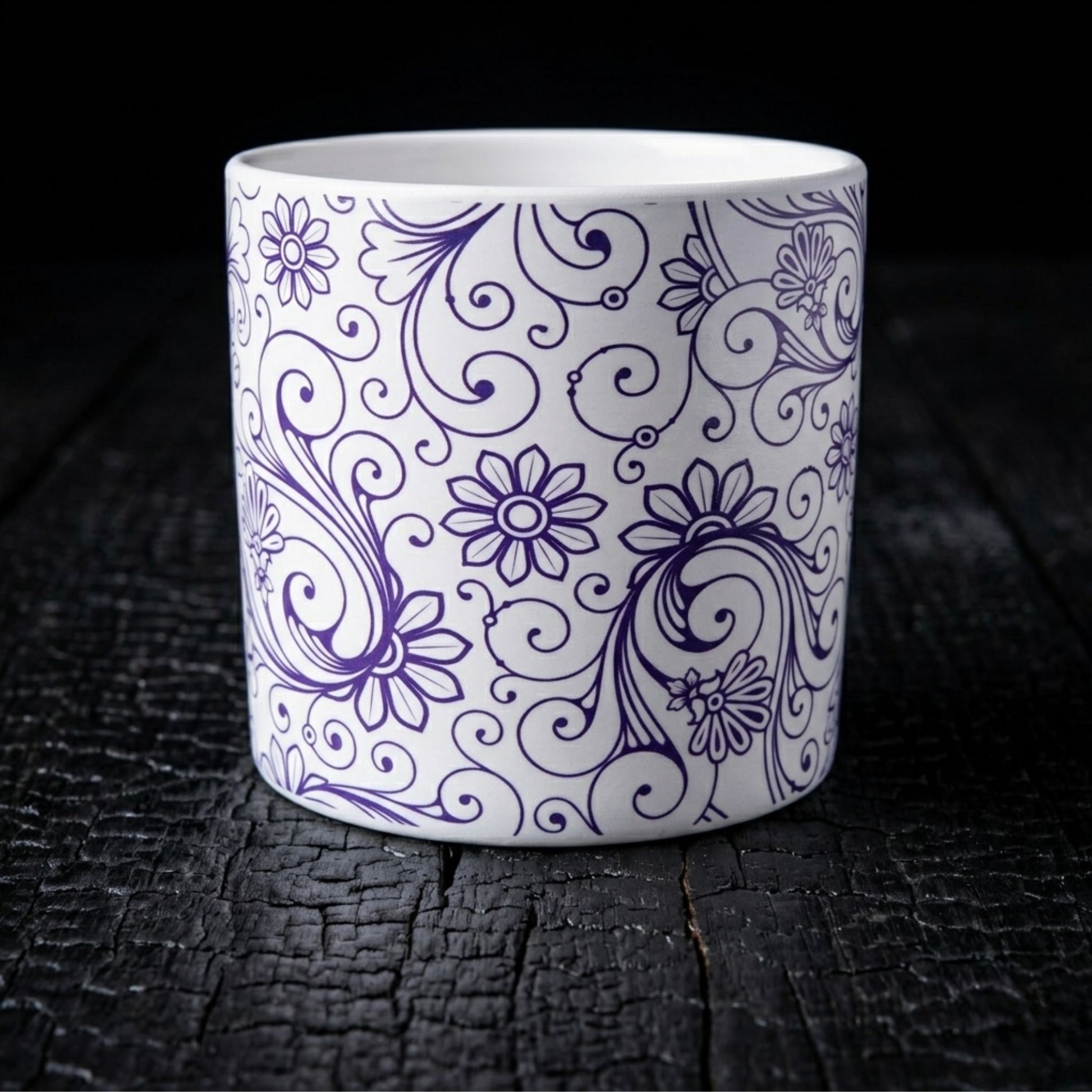 Ceramic plant pot with blue floral patterns on a dark wooden surface