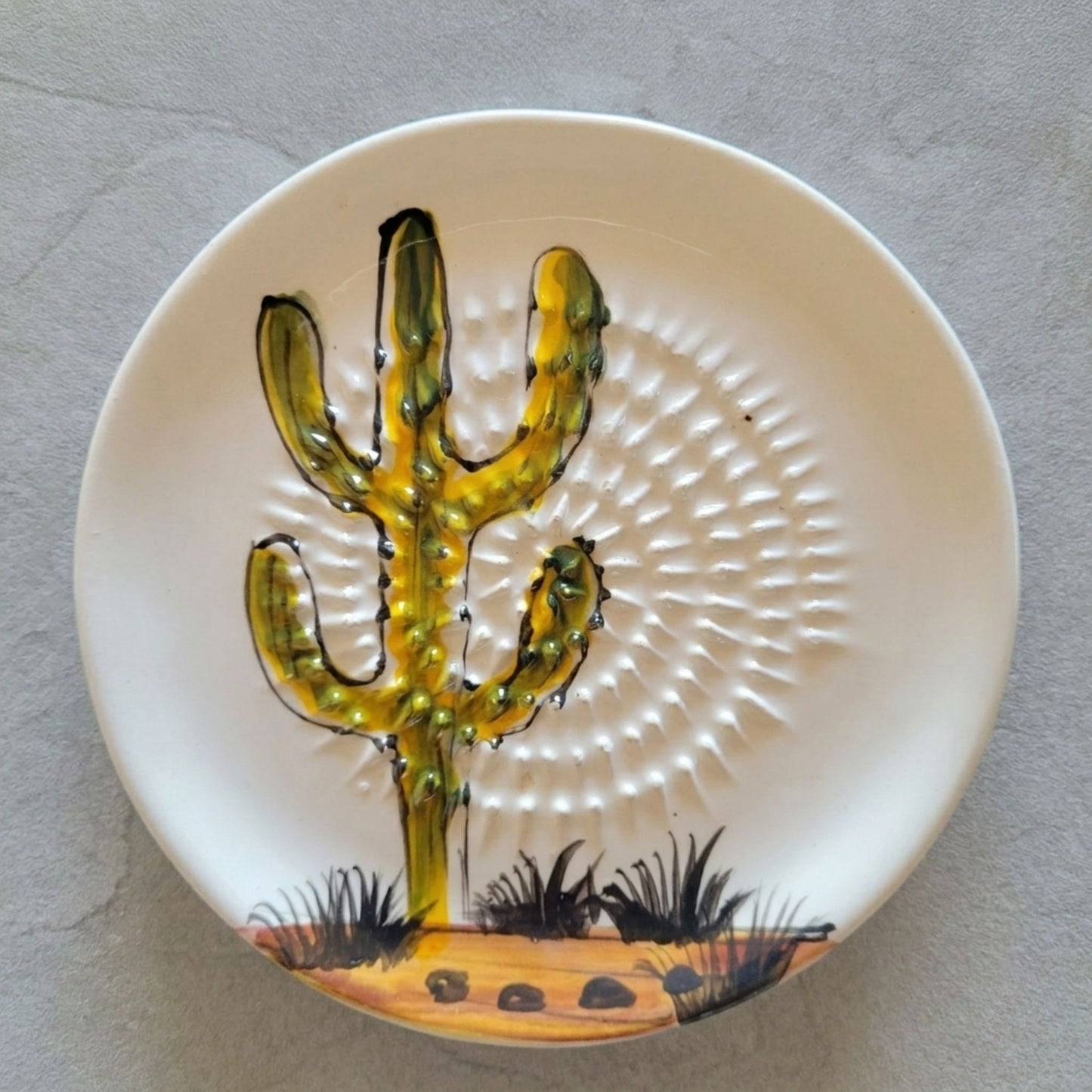 Ceramic grater plate with a cactus design on a gray surface