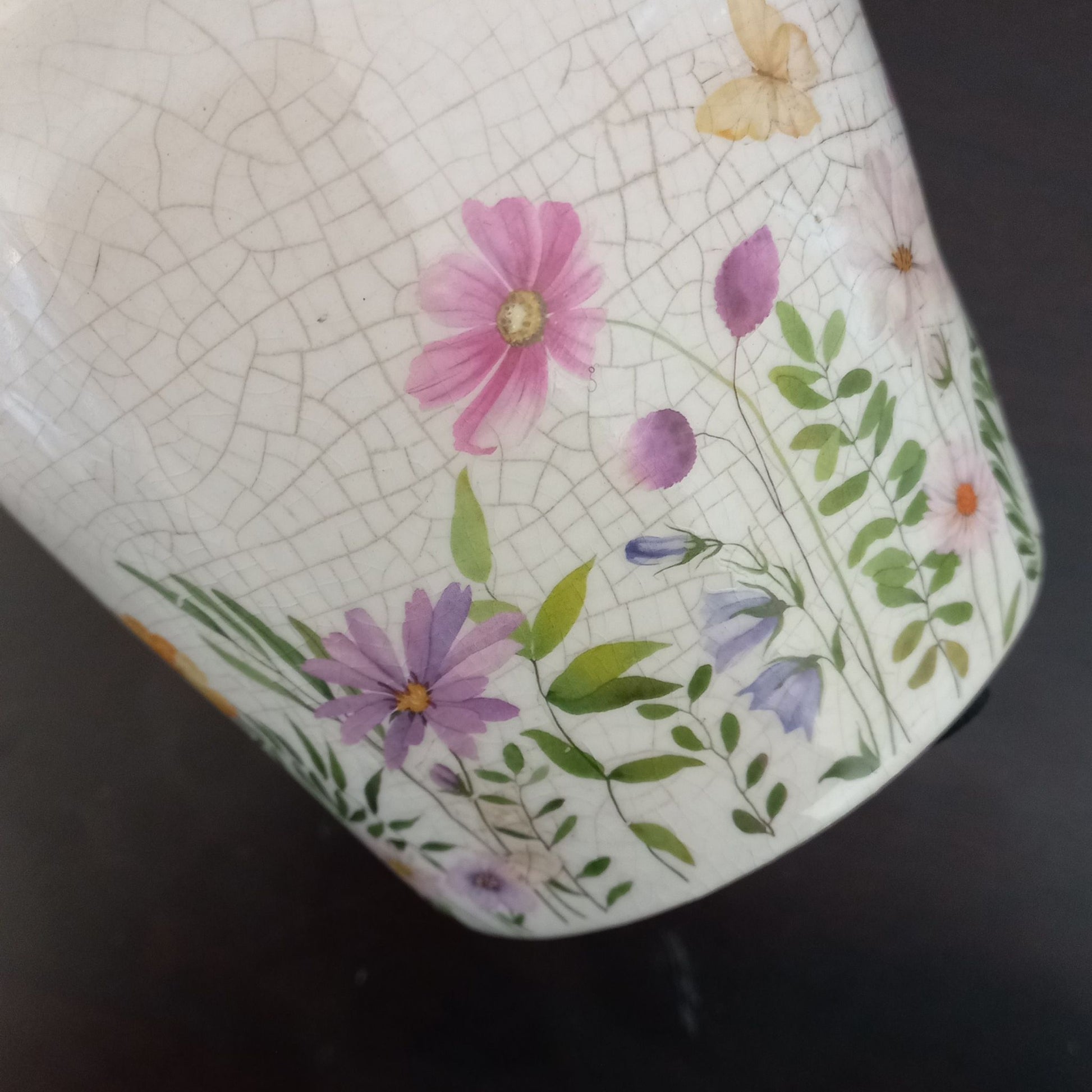 Close-up of a ceramic planter with floral design on a dark background