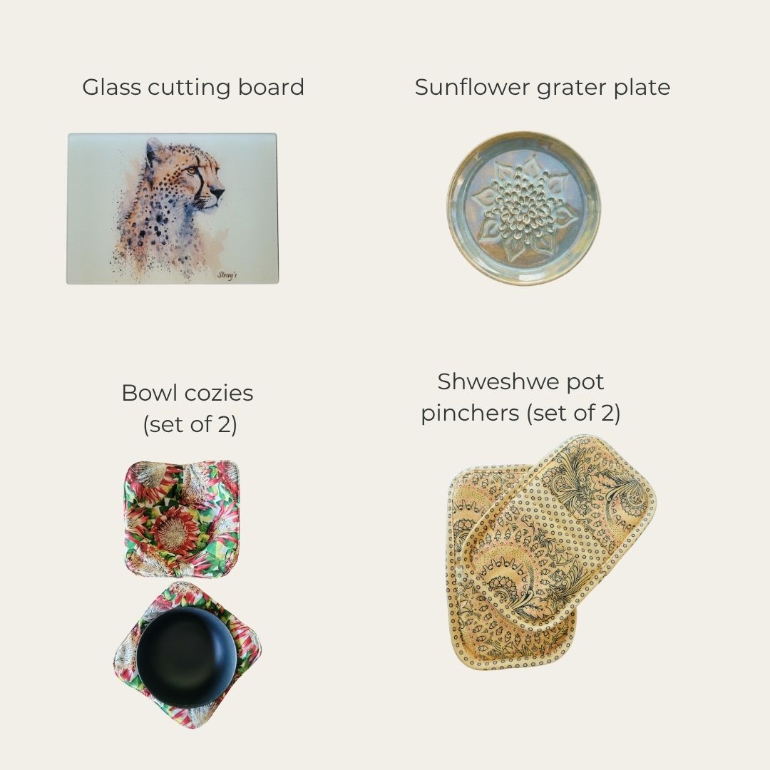 Collection of kitchen items including a glass cutting board, sunflower grater plate, bowl cozies, and shweshwe pot pinchers on a white background.