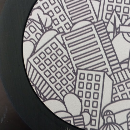 Black and white cityscape design on a circular object