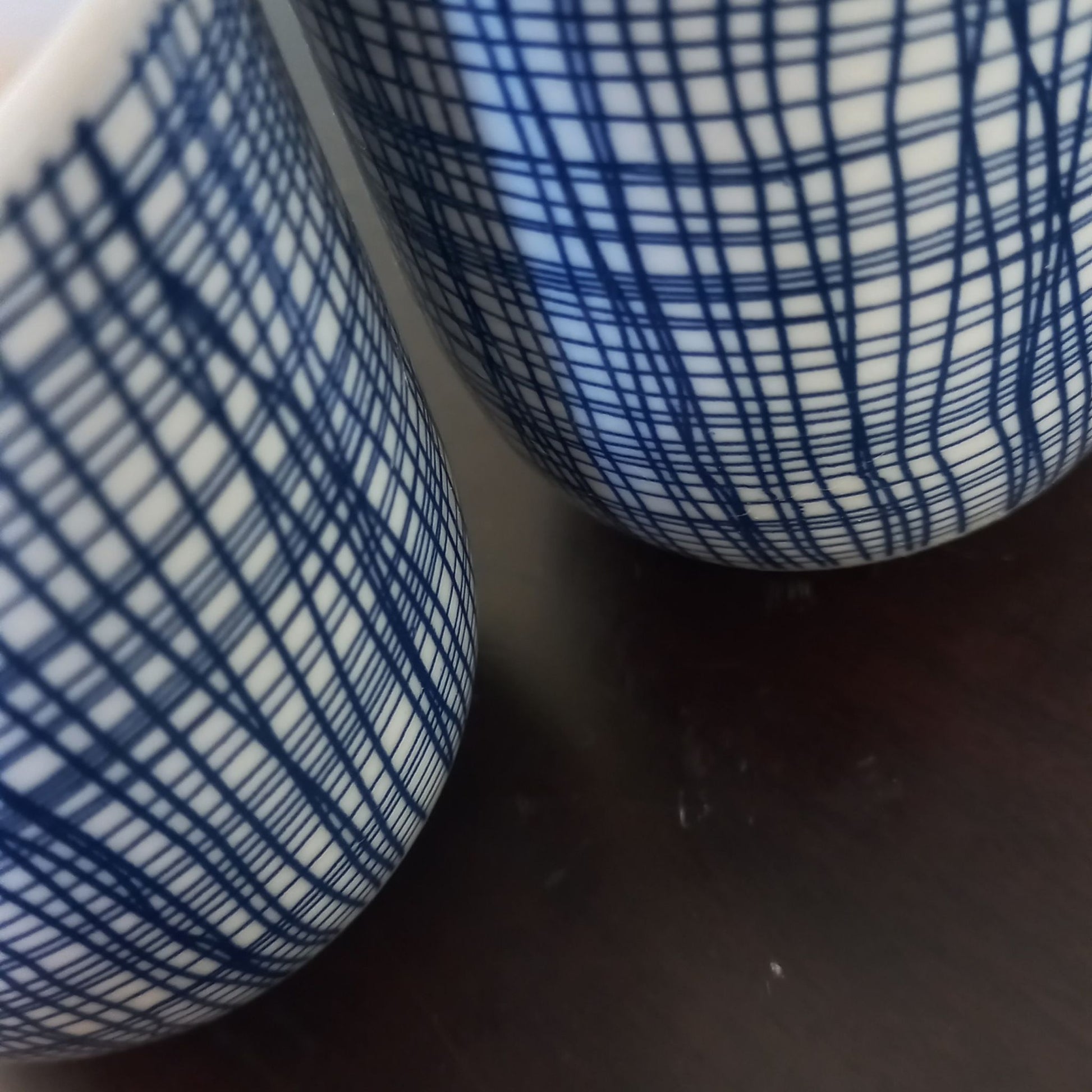 Close-up of a blue and white patterned ceramic tea cups on a dark surface
