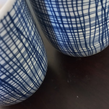 Close-up of a blue and white patterned ceramic tea cups on a dark surface
