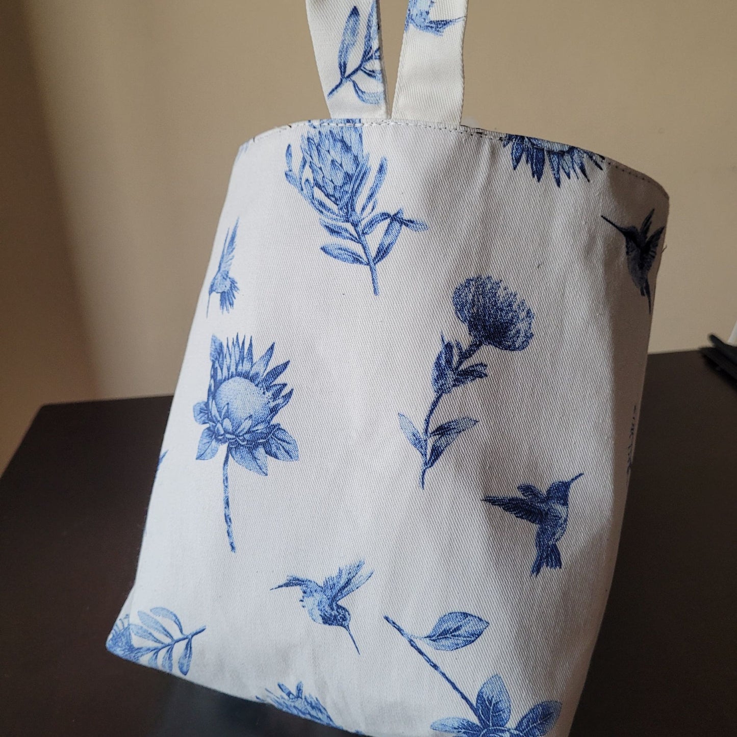 Small car bin with blue floral and bird pattern on a plain background