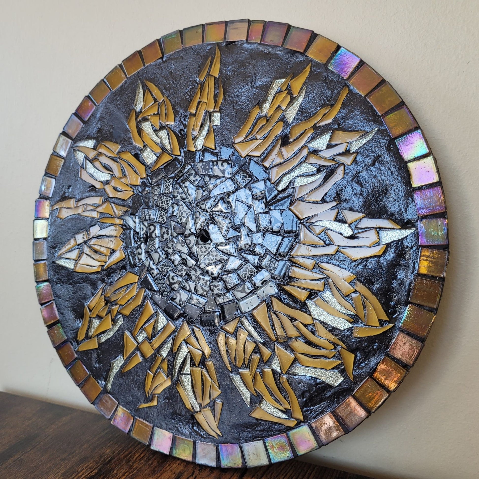 Round mosaic art piece with sunflower design on a neutral background