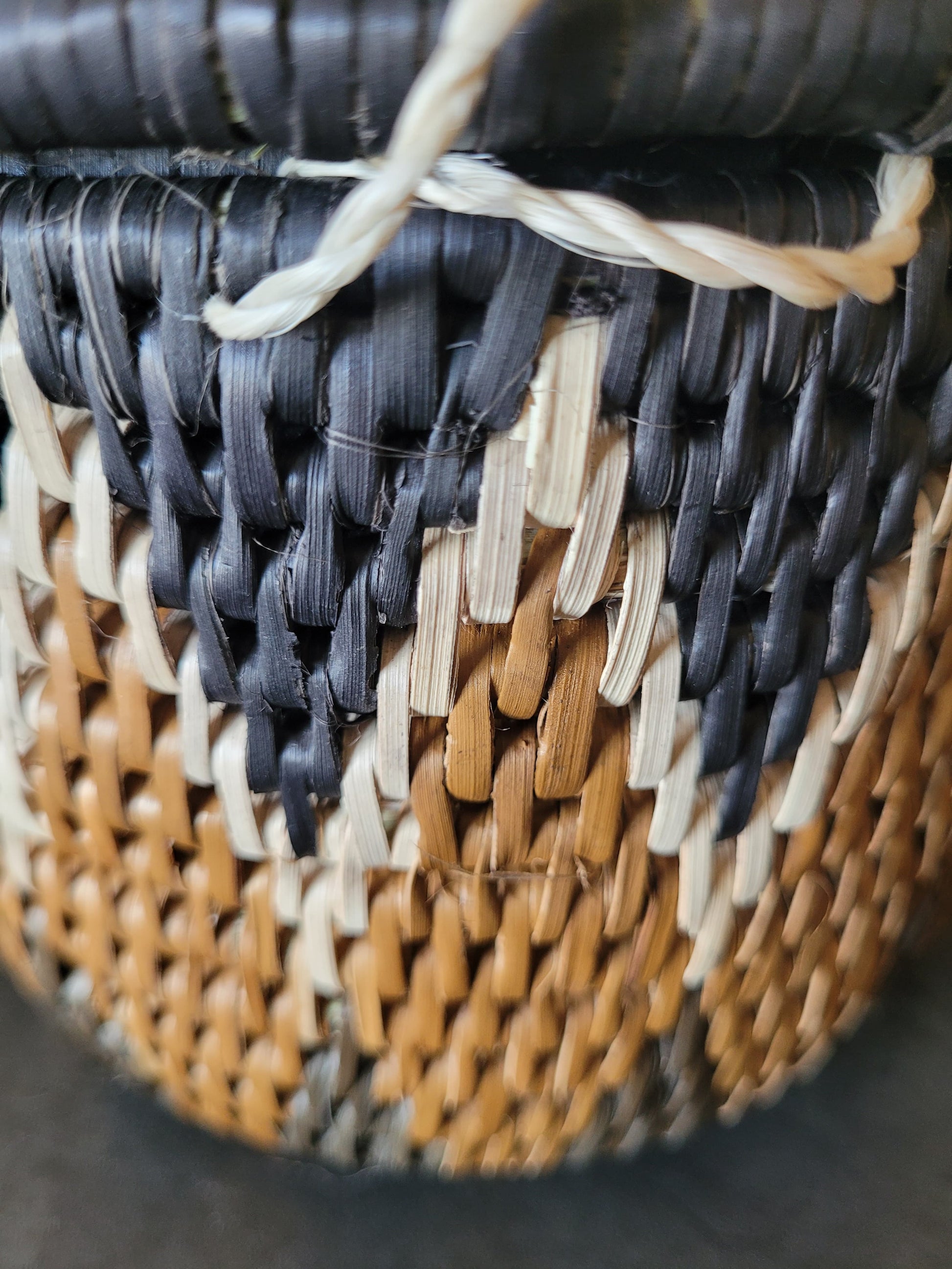 Close-up of a woven basket with black, brown, and beige strands.