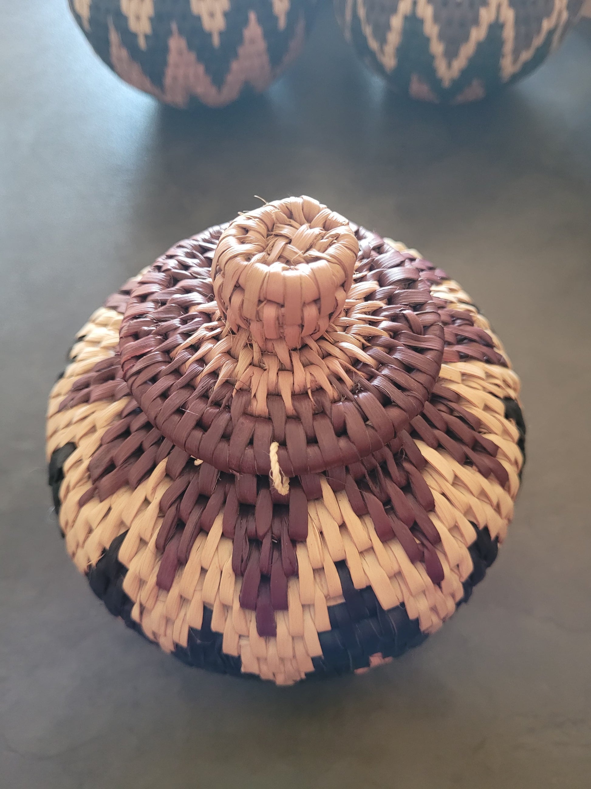 Woven lid on a spherical basket with a dark background
