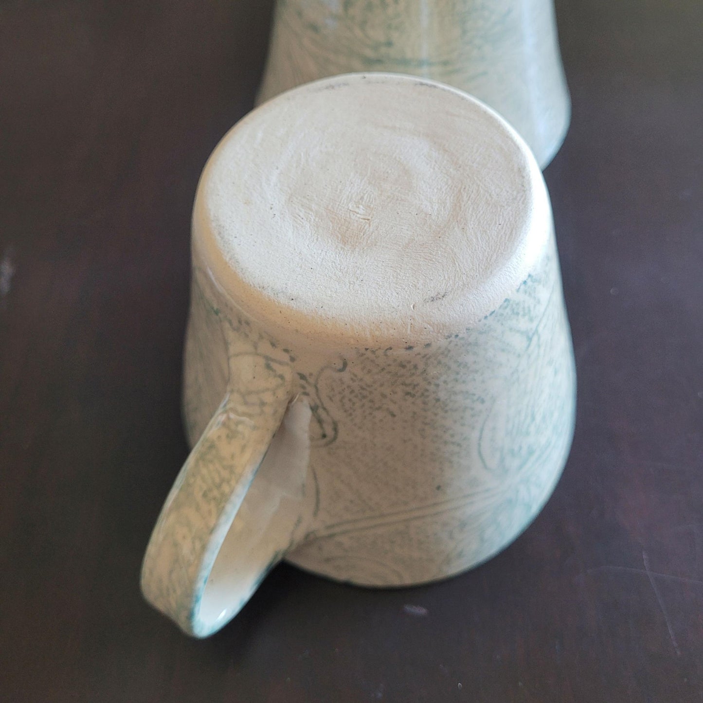 Ceramic mug with handle on a dark surface