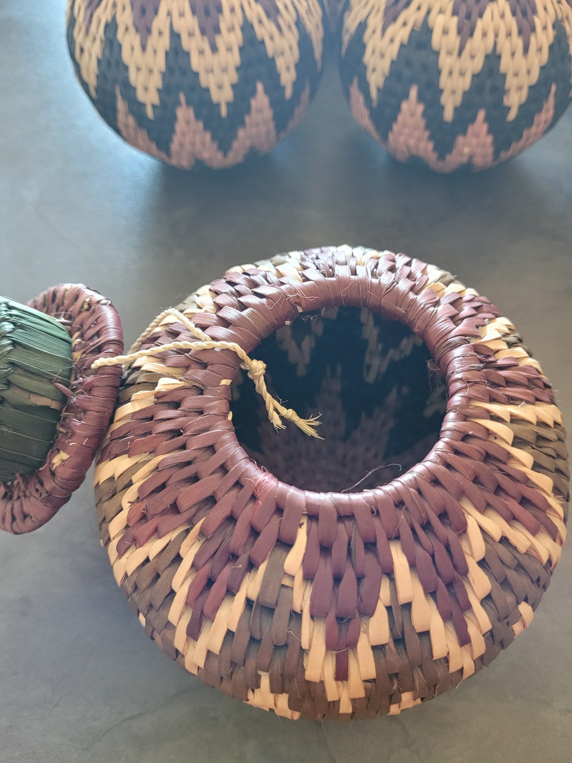 Woven African basket with a pattern on a concrete surface