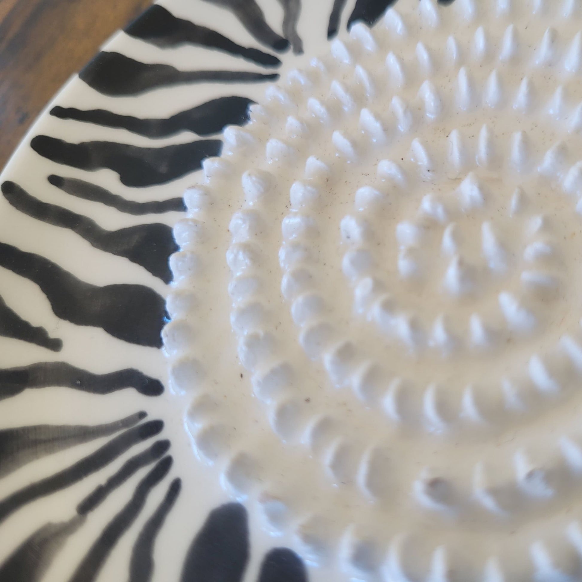 Close-up of african grater plate with zebra pattern and textured design