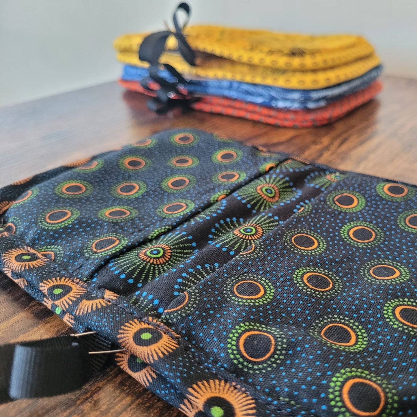Stack of colorful fabric pot holders on a wooden surface