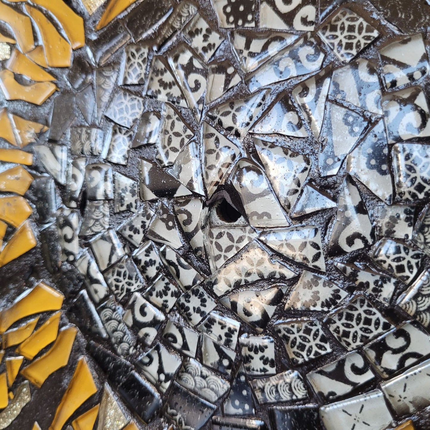 Close-up of a mosaic art piece with various colored tiles.