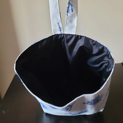 Fabric basket with blue floral pattern on a dark surface