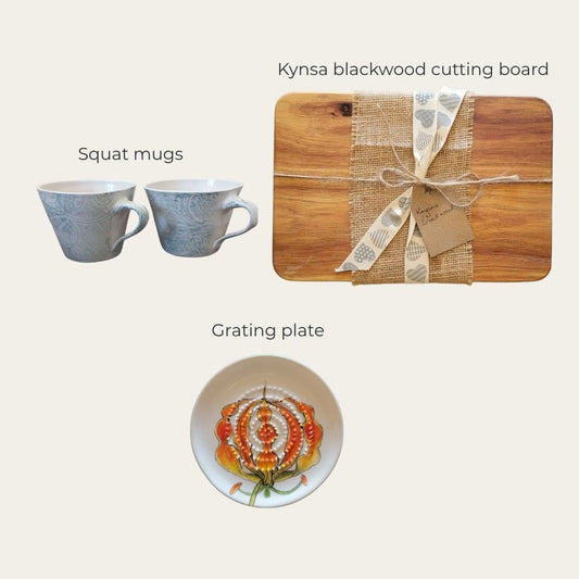 Kynsa blackwood cutting board with a grating plate and squat mugs on a light background