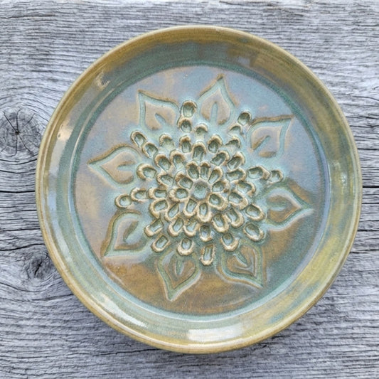 Ceramic grating plate with floral design on a wooden surface